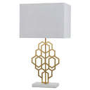 Modern designer table lamp with a black rectangular shade and gold-lined interior, creating a warm ambient glow in a contemporary living room.