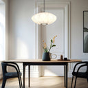 Modern fabric pendant light featuring a sculptural layered shade, adjustable cable suspension, and contemporary ceiling lighting for living spaces.