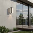 Martec Ashton 10W Tricolour LED Wall Light Modern outdoor wall light fixture on a concrete wall with a view of trees and sky.