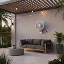 Avalon DC smart wall fan installed in modern covered  Outdoor patio with a gray sofa, round table, and wall-mounted fan under a wooden pergola.