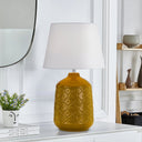 Decorative Baci Table Lamp illuminating a reading nook with soft ambient light and artisan-inspired ceramic craftsmanship.