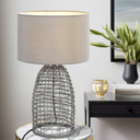Bayz bedside lamp paired with natural timber furniture, creating a warm reading light for a modern bedroom retreat.