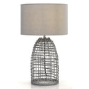 Bayz 40cm Large Table Lamp placed on a timber bedside table, featuring a woven rattan base and soft fabric shade for a relaxed coastal bedroom.