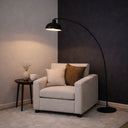 Elegant arc floor lamp illuminating a home office seating area with soft focused light and timeless contemporary aesthetics.