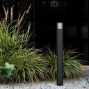Cashel telbix Black outdoor bollard light Garden light fixture in a garden setting with grasses and gravel.