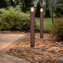 Cashel telbix Corten outdoor bollard lights outdoor garden lights on a stone pathway with greenery in the background