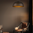 Cassidy Designer Pendant Light above a Modern chair with brown cushions in a dimly lit room.