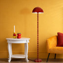 Side profile of the Estiq Floor Lamp highlighting the slim sculptural frame, rounded metal shade, and balanced circular base.