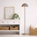 Designer reading lamp illuminating a cosy corner with focused downward light and an elegant twisted iron stem.