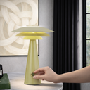 Halvik a Green table lamp with a hand turning a switch on a modern interior setting