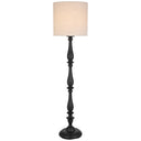 Hommer Floor Lamp positioned beside a linen sofa, featuring a turned black base and beige fabric shade for warm contemporary living room lighting.