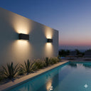 Martec Integra 6W/10W Tricolour LED Up/Down Wall Light Modern outdoor wall lights by a pool at night with a scenic view. Lights and Fans Online 