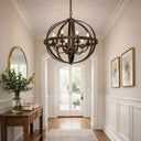 Lincon pendant light with 6 Lights in  an elegant Foyer with a large chandelier, wooden console table, and framed pictures on the wall.