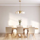 Marsten 5 Pendant Light in Antique Gold with five glass globes Dining room with a wooden table and chairs under a gold pendant light.