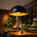 Newport Industrial Large Pendant Light 70 cm Black Dome with Gold Interior hanging above a wooden table in a cozy restaurant setting. Lights and Fans Online 