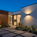 Nova Tricolour LED Wall Light in a Modern house exterior with outdoor lighting and plants at night from Lights and fans online