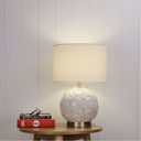 ARIEL Ceramic Table Lamp with Shade on a wooden side table against a light gray wall.