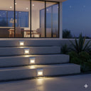 Quattro Recessed Tricolour LED Step Light in a Modern outdoor staircase with built-in lights at night, leading to a house from Lights and Fans Online 