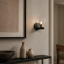 Telbix Radam Interior feature lighting with RADAM designer wall light Wall-mounted sconce with a glass shade on a neutral wall, with vases and a bowl on a console table below.