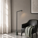 Premium architectural floor lamp photographed in a contemporary apartment, showcasing the harmonious combination of marble, iron, and warm LED illumination.