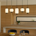 Luxury Torso LED bar pendant with decorative rippled and diamond-cut glass shades for elegant contemporary dining room lighting.