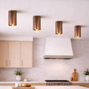 TORESS Small Acid Surface Mount Light   in a Modern kitchen with metallic ceiling lights, white range hood, and light wood cabinets.