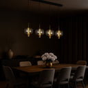 Modern 4-light linear LED pendant featuring smoke glass shades, matt black finish, and designer ceiling lighting for dining rooms.