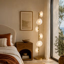 Contemporary floor lamp with six G9 glass shades creating warm decorative illumination in a sophisticated lounge or reading corner.