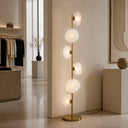 Luxury standing lamp positioned beside a sofa, combining handcrafted glass artistry with a sleek metal frame for elegant ambient lighting.