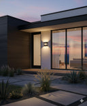 KENT Bronze Wall Light by Martec MDA Lighting installed on brick wall”Modern house exterior with large windows and a sunset view.