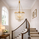 Maddisson 3 lights WHite Wash Gold Chandelier hanging above a staircase in a well-lit room with a lamp and flowers on a table.